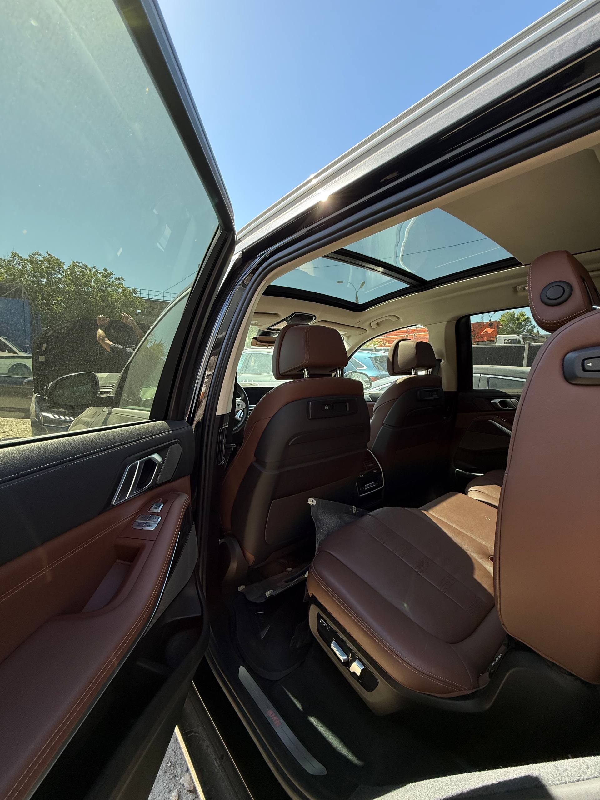 Interior BMW X7, bancheta din spate din piele maro și trapa panoramică