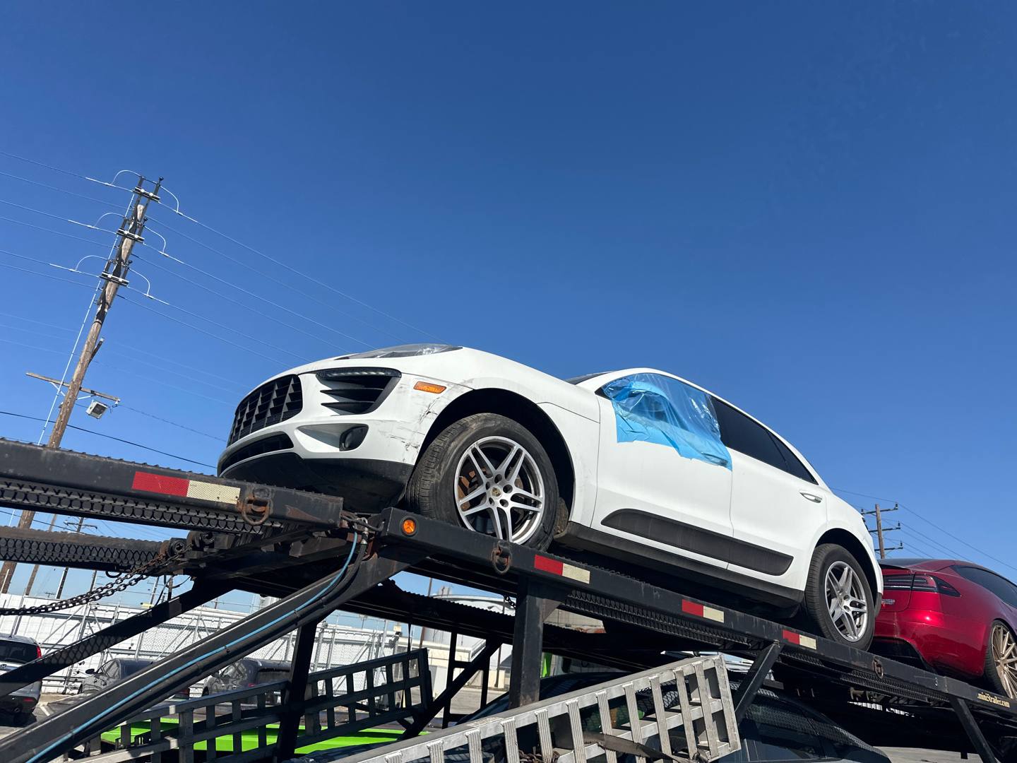 Porsche Macan încărcat pe platforma de transport, pe drum spre port